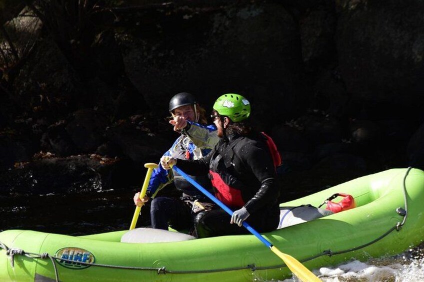 Deux personnes se trouvent dans un radeau gonflable vert sur une rivière. 1