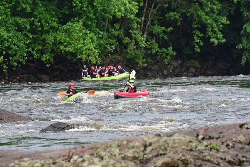 Un groupe de personnes pratiquant le kayak sur une rivière, entourée d’une végétation luxuriante. 4