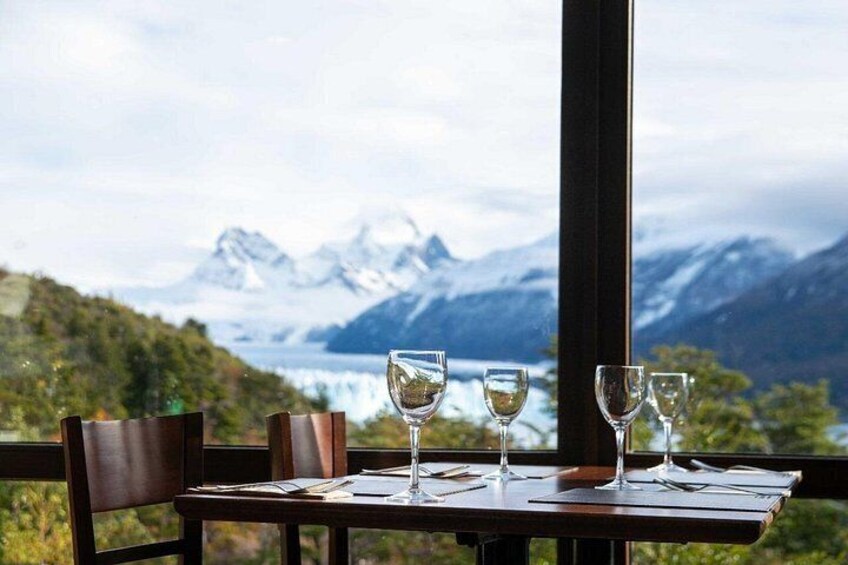 A table with three wine glasses and a menu, set against a backdrop of a mountainous landscape with a lake. 5