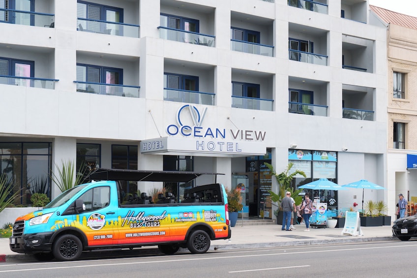 A colorful bus with 'Hollywood Bus Tours' branding parked in front of the Ocean View Hotel. 2
