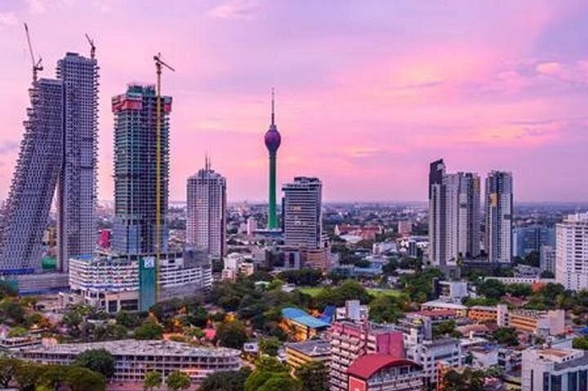 A cityscape with modern high-rise buildings, a distinctive tower, and a construction site. 2