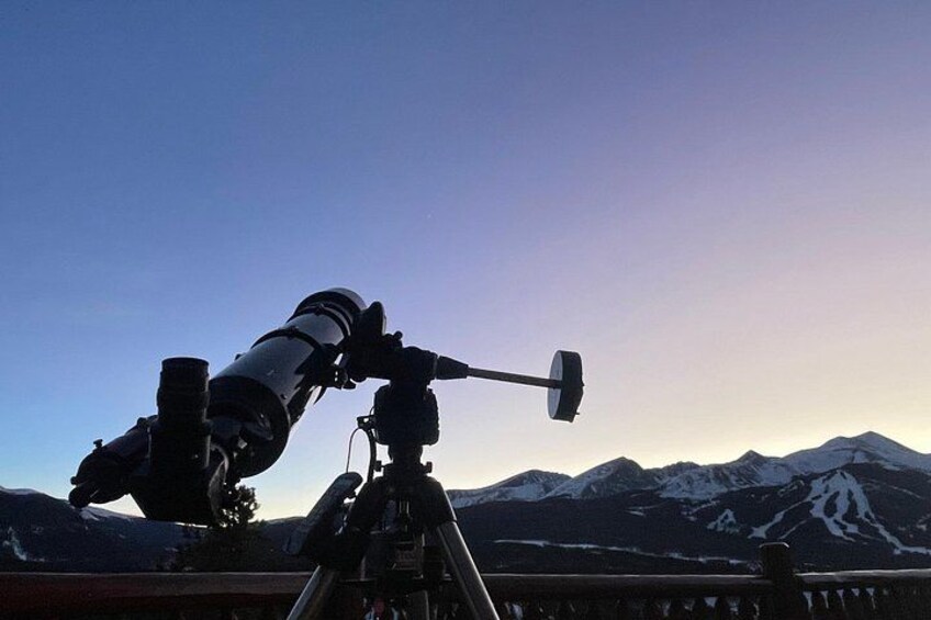 A telescope on a tripod overlooking a mountainous landscape. 3