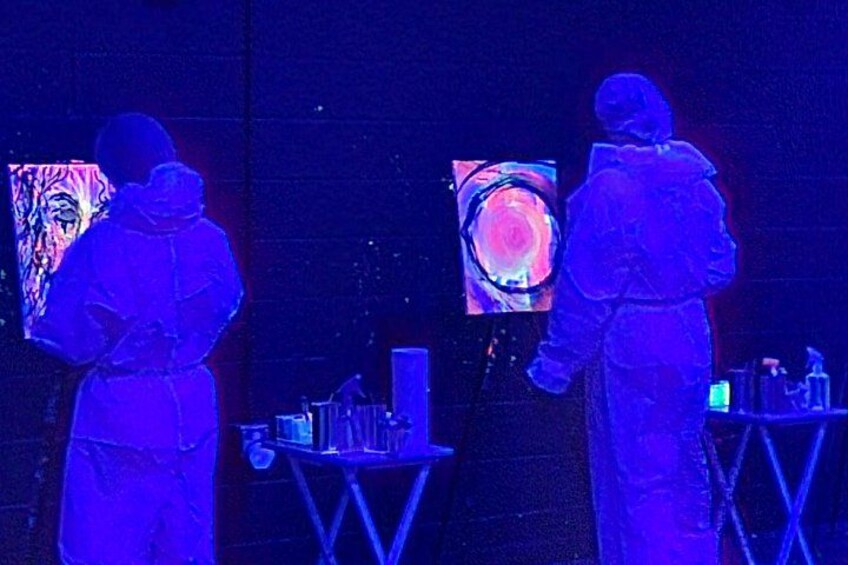 A couple freestyling in the glow-in-the-dark painting main room 2