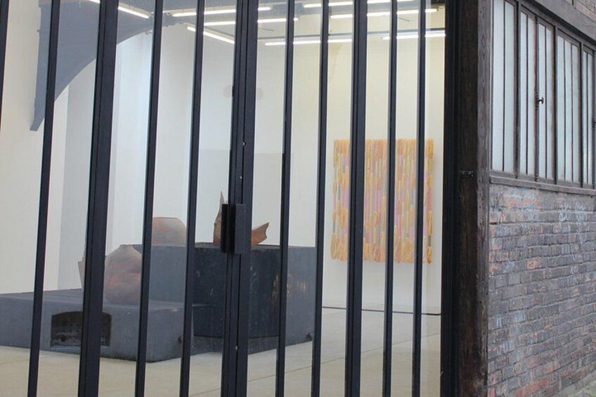 Een kamer met een zwart metalen hekwerk, een blauwe bank en een schilderij aan de muur. 4