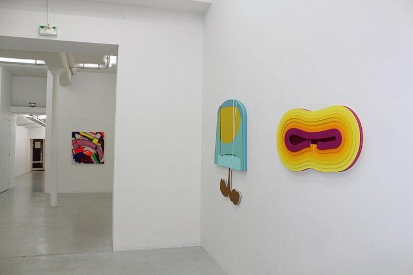 Een kunstgalerie met witte muren en enkele kunstwerken. 3