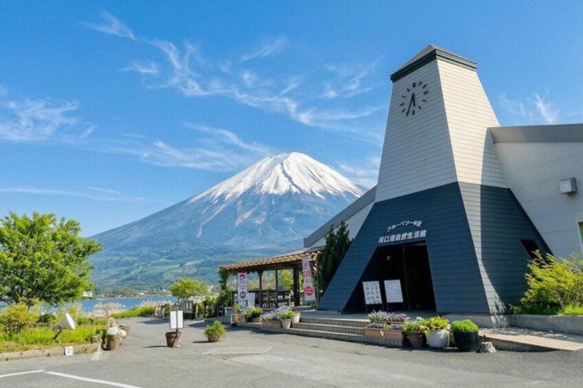 A building with a clock tower, a parking lot, and a view of a snow-capped mountain. 5