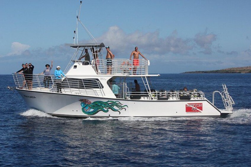 A white boat with a dragon design, people on deck, and a clear blue sky. 2