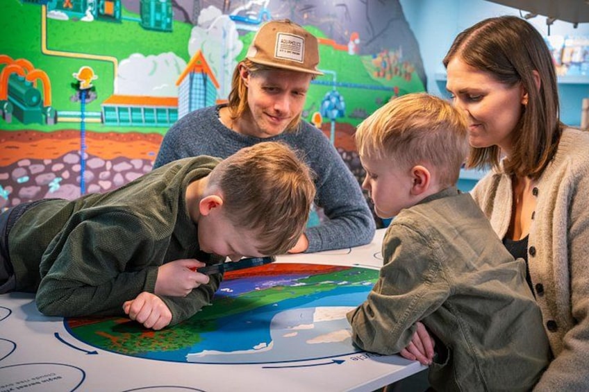 A group of people examining a colorful map at a table. 5