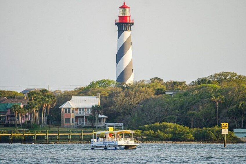 Een vuurtoren, een boot en een huis aan het water. 1
