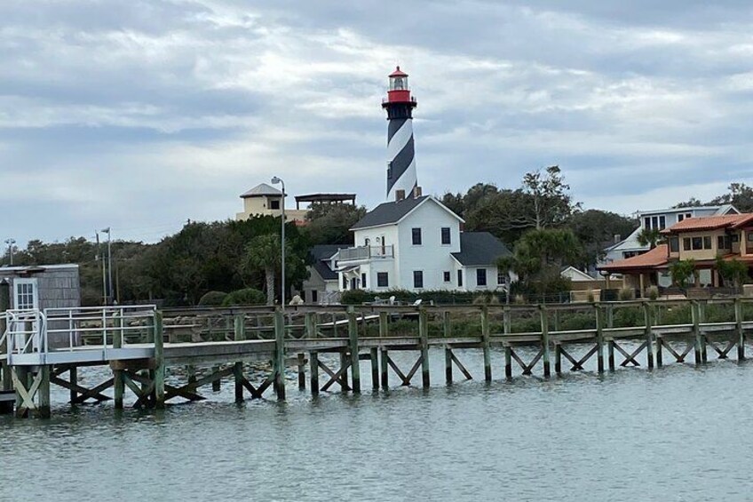 Un phare, une jetée en bois et des immeubles d’habitation situés au bord de l’eau. 2