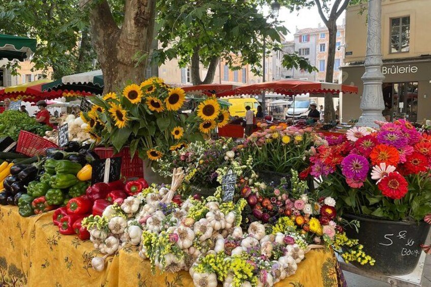 Un puesto de mercado con verduras y flores. 4