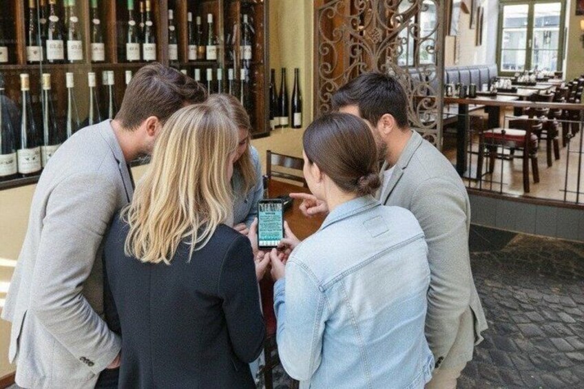 A group of people in a wine cellar with bottles on shelves. 2