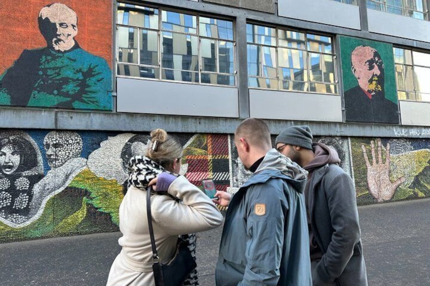 A mural with portraits and abstract art on a building wall. 2