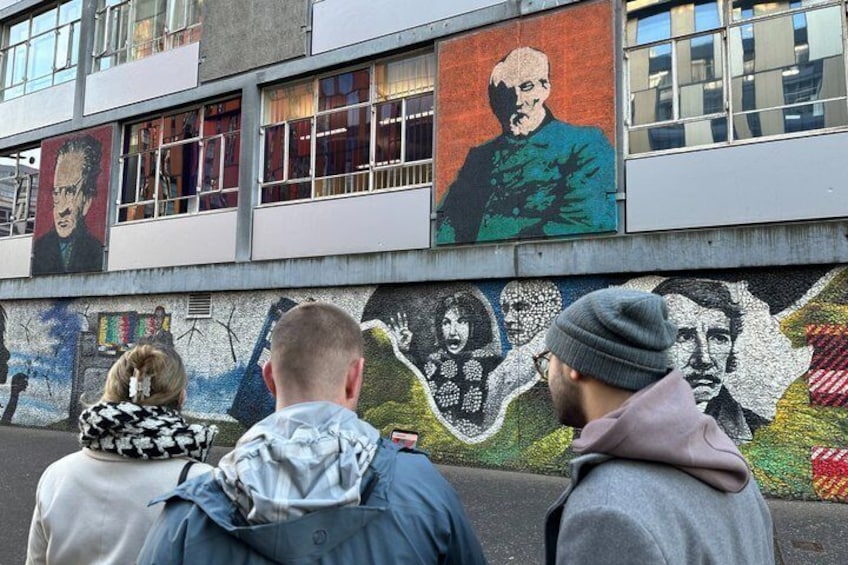A mural on a building with various figures and scenes. 4