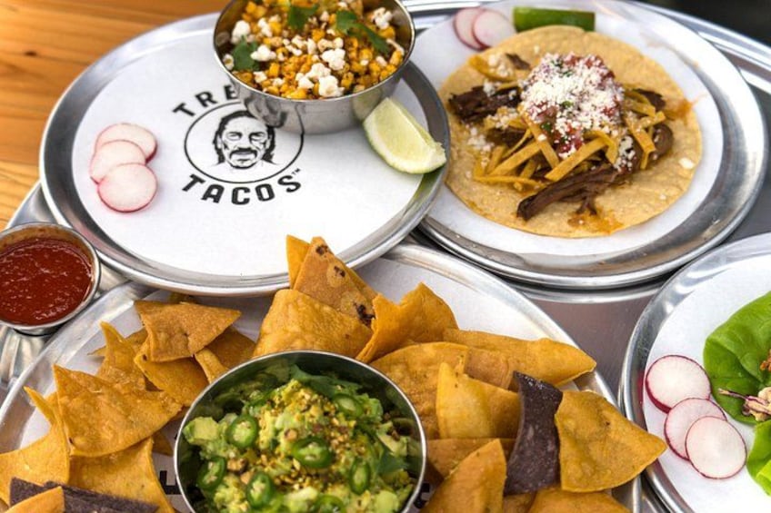 A variety of Mexican dishes including tacos, nachos, and guacamole. 2
