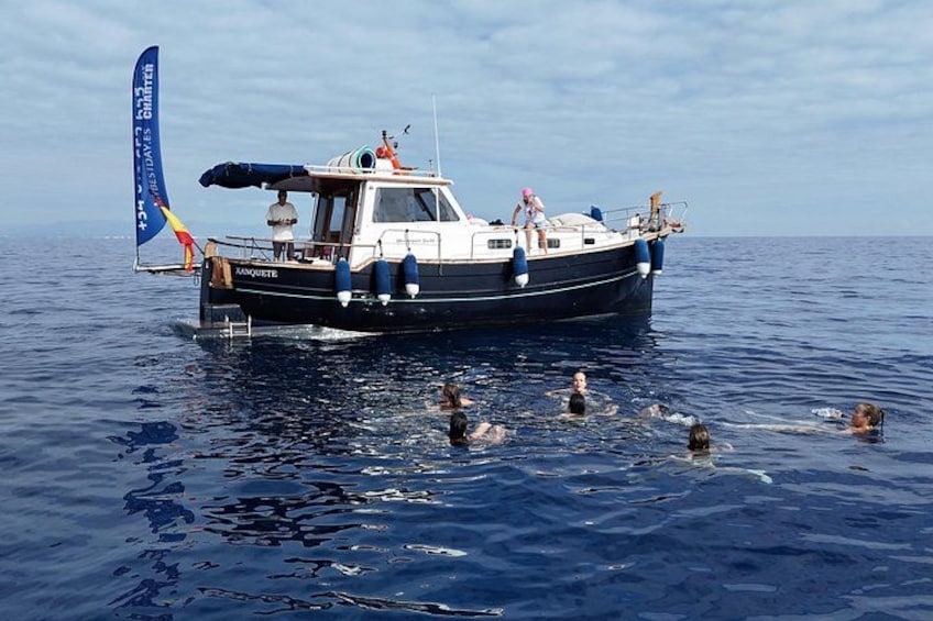 Una embarcación llamada 'MAMQUETTE' con gente nadando en el agua. 1