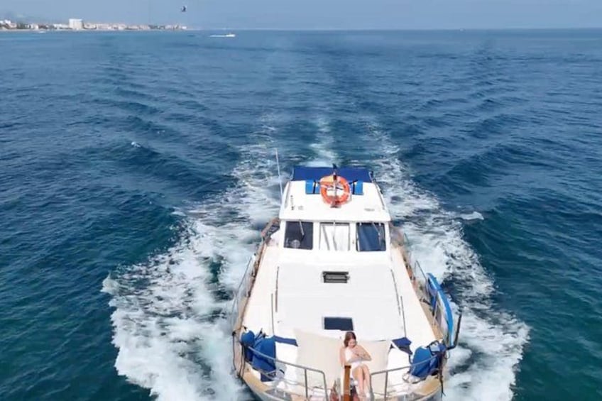 Un barco navegando por el océano con una persona de pie en la proa. 3