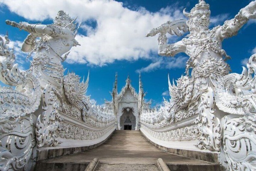 Een wit, versierd tempel met ingewikkelde decoraties en een helderblauwe lucht. 1