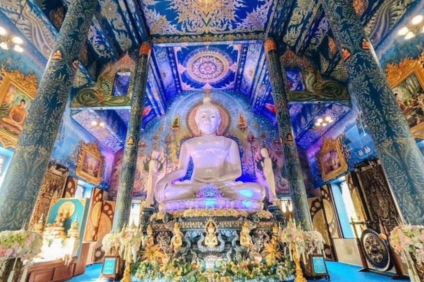 Eine große Buddha-Statue in einem Tempel mit aufwendigen, blau und goldenen Verzierungen. 3