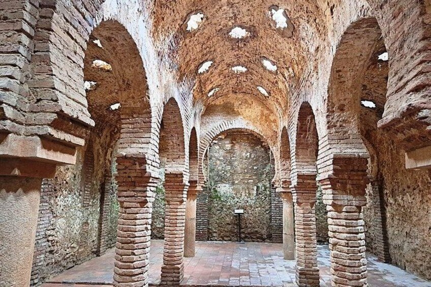 An ancient stone structure with arched ceilings and columns. 2