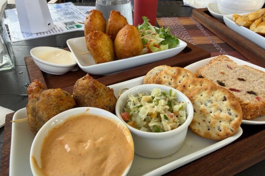 A tray with food items including bread, coleslaw, and a creamy sauce. 2