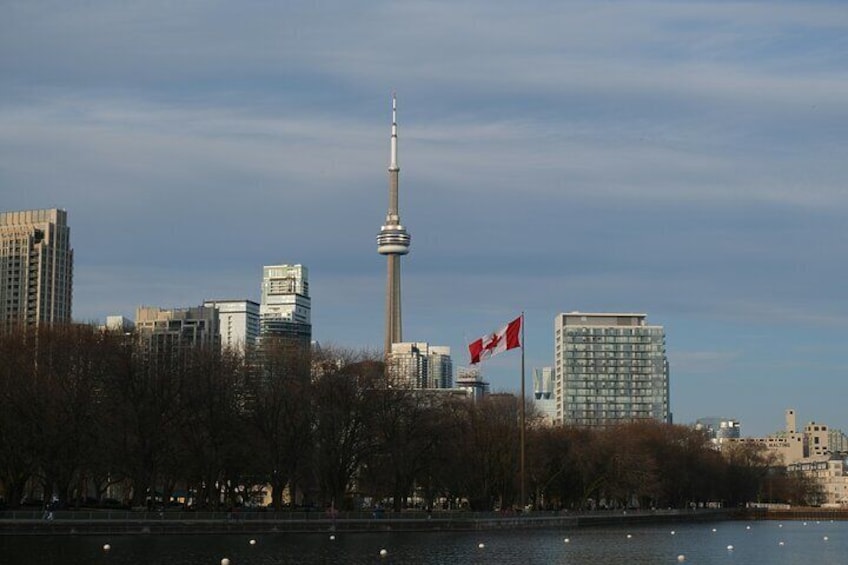 A city skyline with a prominent tower, a body of water, and flags. 3
