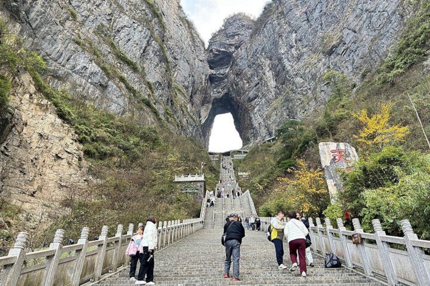 A stone staircase leading up a mountain with a large rock formation at the top. 2