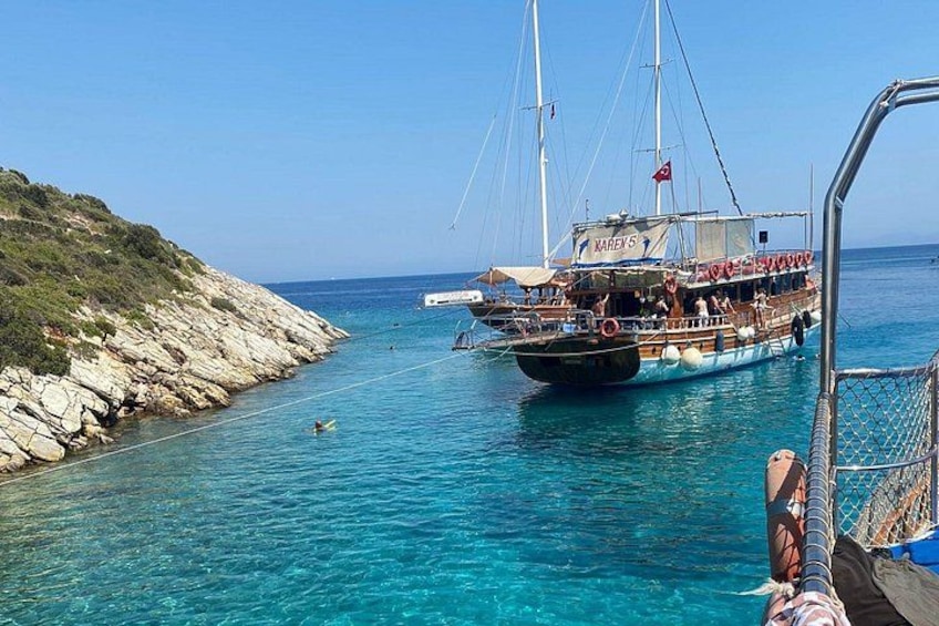 Un bateau nommé « KARAY 5 » a accosté sur une côte rocheuse, dans une eau d’un bleu limpide. 2