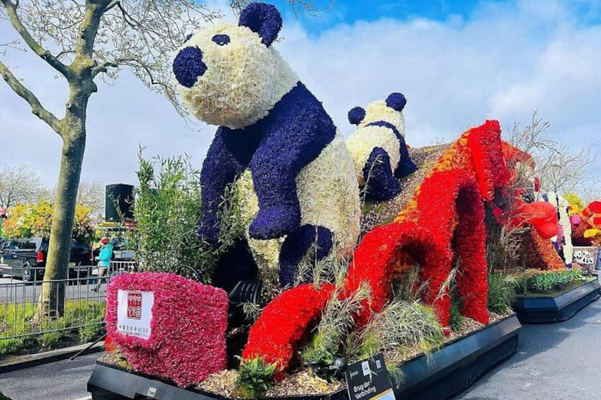 A large panda sculpture made of flowers, surrounded by other floral arrangements. 3