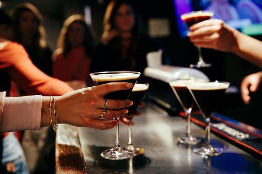 A bar setting with people holding martini glasses. 5