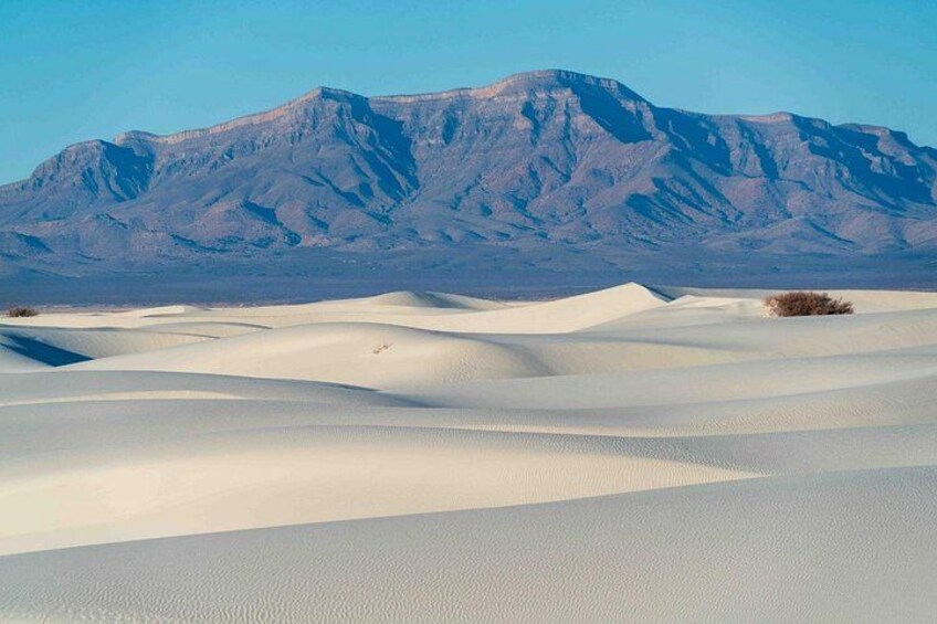 Wüstenlandschaft mit Sanddünen und einem Gebirgszug im Hintergrund. 2