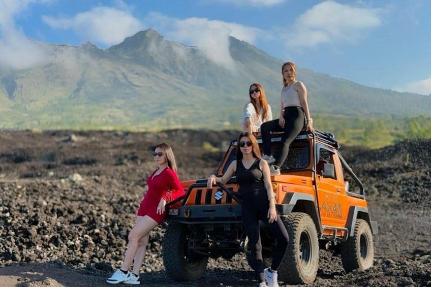 Three people on a vehicle with a mountainous landscape in the background. 5