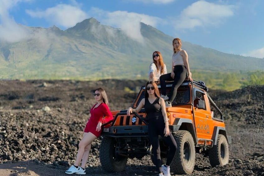 A group of people on a vehicle with a volcanic landscape in the background. 4