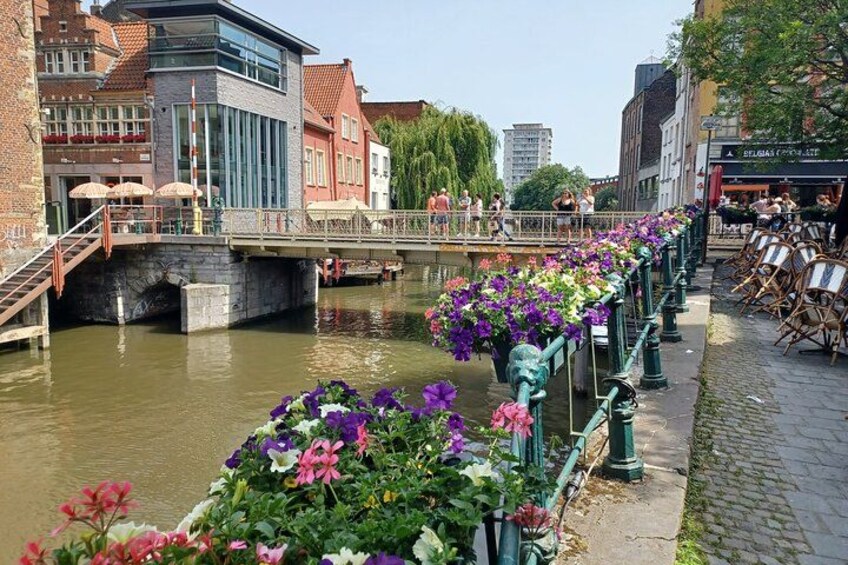 Un canal con un puente, paseo bordeado de flores y edificios. 2