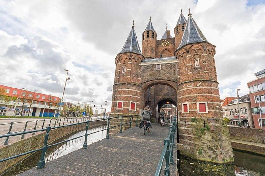 A historic brick tower with a clock, a bridge, and a canal. 3