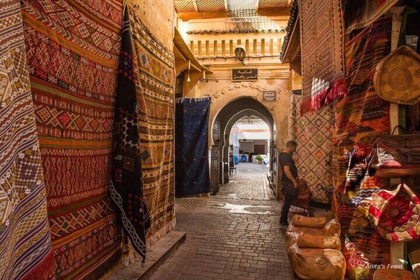 Un callejón estrecho con alfombras y textiles decorativos. 5
