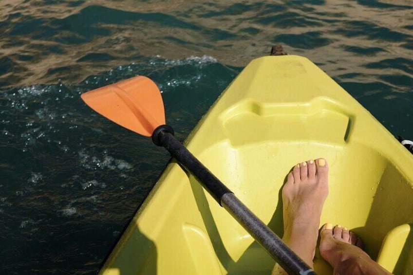 Ein gelbes Kajak mit einer Person, die auf ruhigem Wasser paddelt. 1