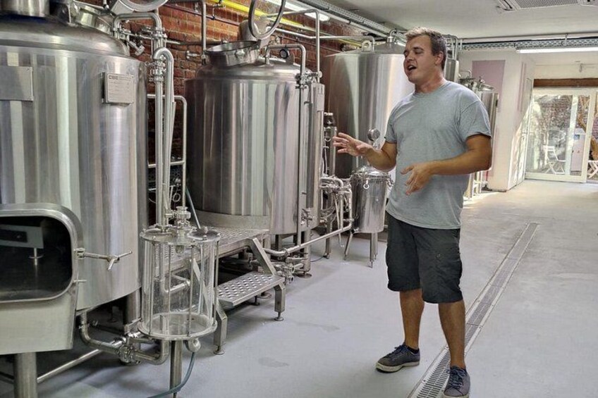 Una persona de pie junto a maquinaria de elaboración industrial en una instalación. 2