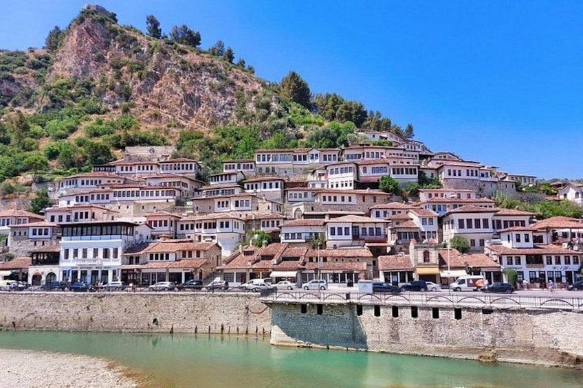 A coastal town with terraced houses, a bridge, and a rocky hillside. 2