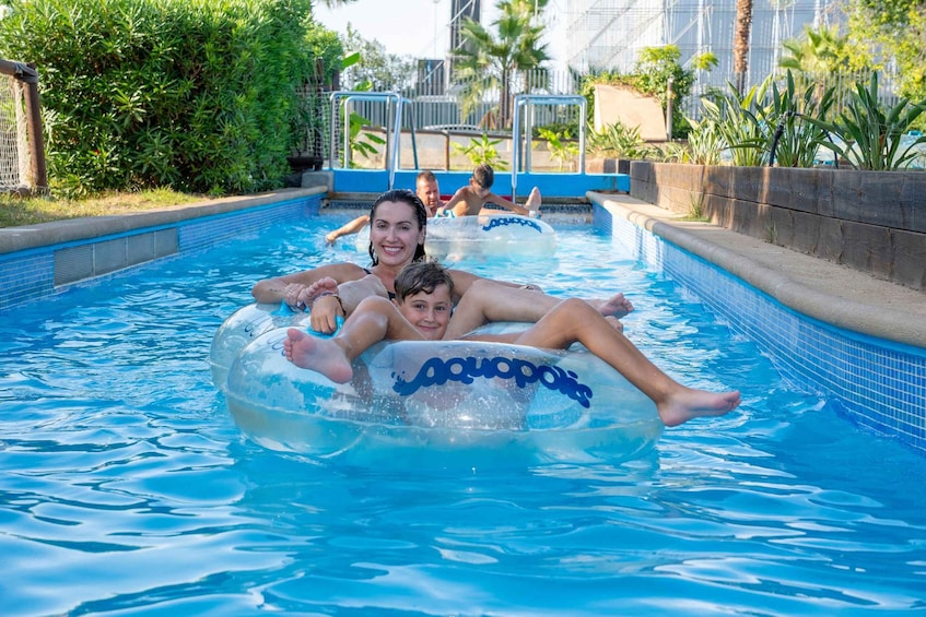 People floating on water in a pool with a tropical setting. 5