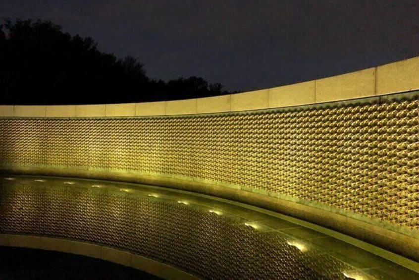 A curved wall with a textured pattern and lights along its edge. 4