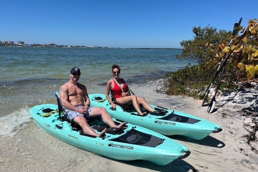 Due persone su una spiaggia con kayak. 1