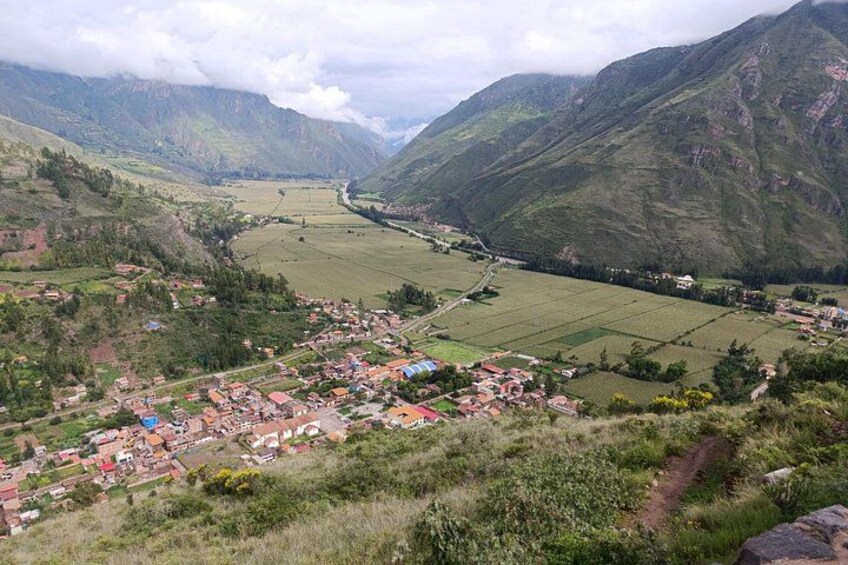 A valley with a river, houses, and mountains. 2