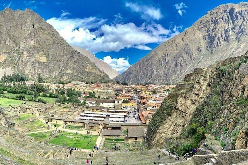 A mountainous landscape with a town nestled in a valley, terraced fields, and a prominent mountain in the background. 1