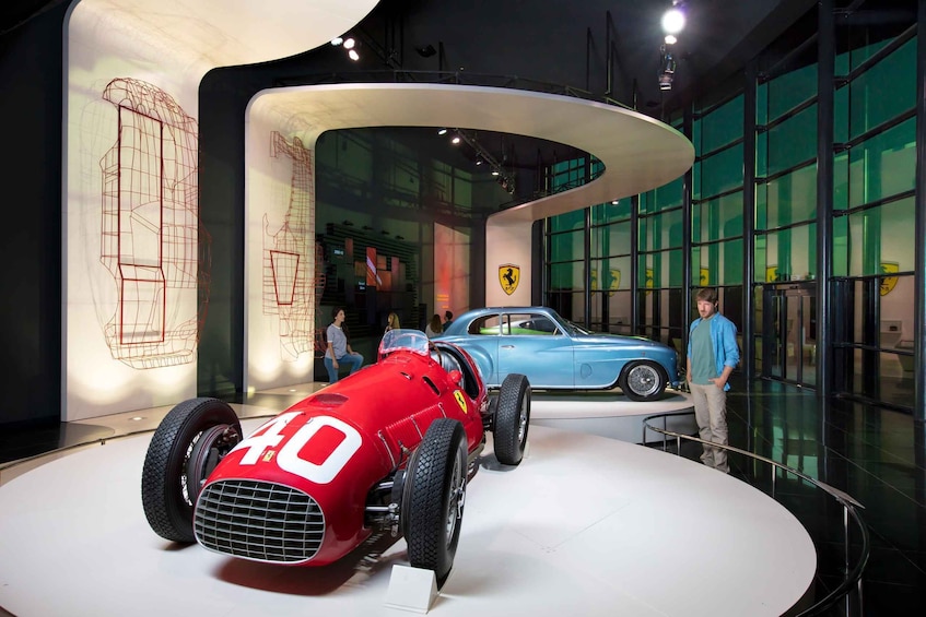 En röd och blå, klassisk sportbil från förr visas upp på ett museum. 1