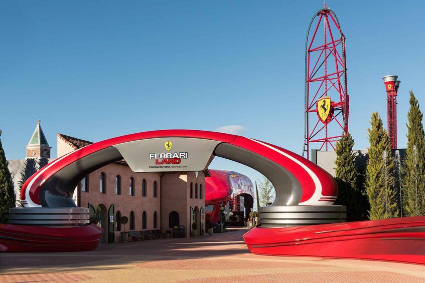 A Ferrari Land entrance with a red archway, a Ferrari logo, and a tall red tower in the background. 2