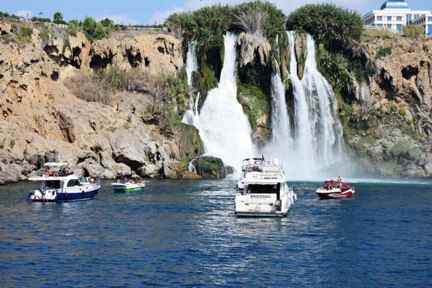 A large waterfall, boats, and rocky cliffs. 5