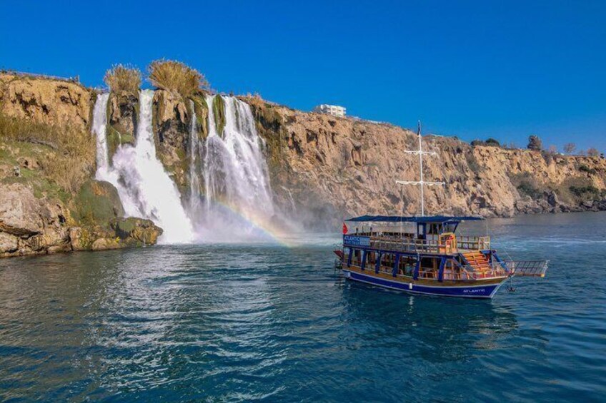 A boat near a waterfall with a rainbow. 4
