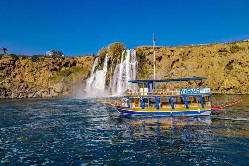 A boat named 'ATLANTIC BOAT TOURS' on calm waters with a waterfall in the background. 3