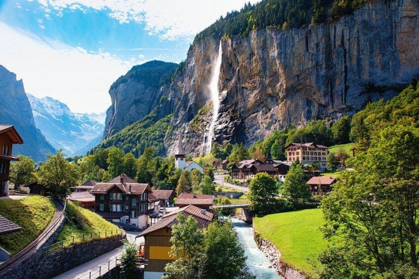 A village with houses, a river, and a waterfall. 1